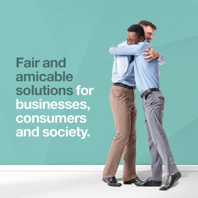 Two professionals embracing in a warm handshake, symbolising fairness and collaboration, with text reading ‘Fair and amicable solutions for businesses, consumers and society’ on a teal background.